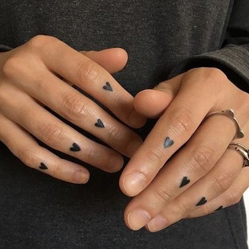 Finger-Tattoo mit minimalistischen Symbolen