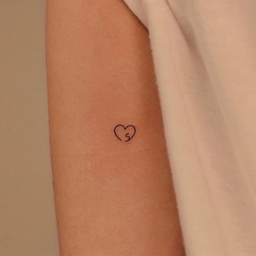 Tattoo Buchstabe mit Herz auf dem Unterarm