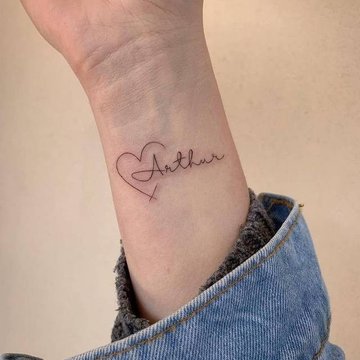 Herz-Tattoo auf dem Handgelenk in zarter Linienführung