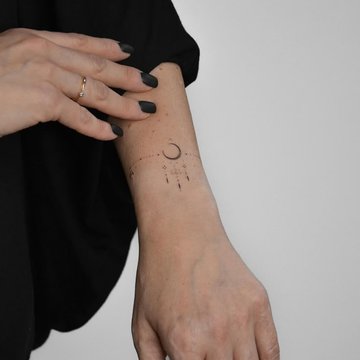 Kleines Symbol-Tattoo bei einer jungen Frau