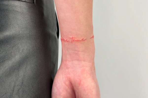 Schriftzug-Tattoo entlang des Handgelenks
