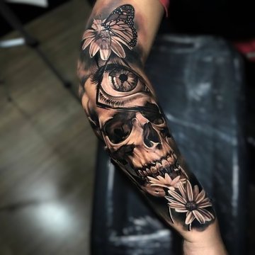 Tattoo eines Schmetterlings mit Totenkopf auf dem Unterarm