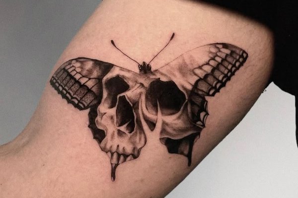 Tattoo auf der Hand: Totenkopf im Schmetterlingskörper