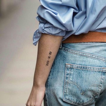 Römische Zahlen als Teil eines Armbandes tätowiert