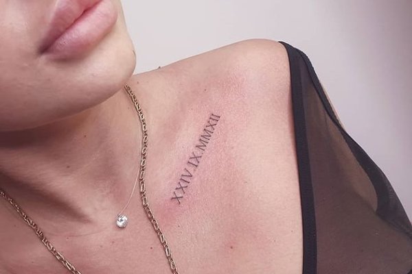 Elegantes römisches Zahlen-Tattoo auf dem Schlüsselbein