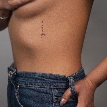 Tattoo mit Spruch auf den Rippen