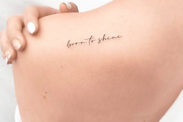 Tattoo mit Lebensmotto auf dem Rücken