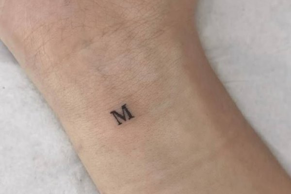 Feines Buchstabe M Tattoo am Handgelenk