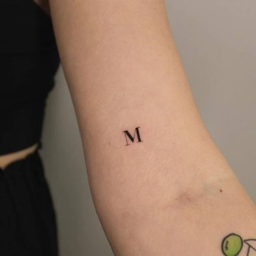 Tattoo mit Buchstabe M und Initiale eines Namens