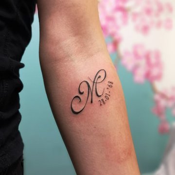 M als Erinnerungstattoo mit Datum