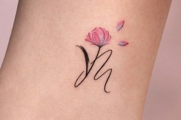 M mit floralen Ornamenten als Tattoo