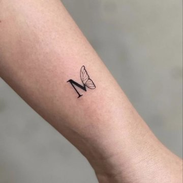 Tätowierter Buchstabe M mit Flügeln