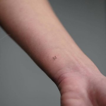 Feines Buchstabe M Tattoo am Handgelenk