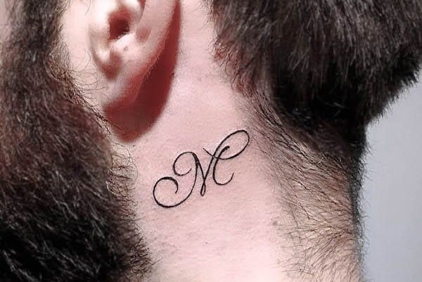 Buchstabe M hinter dem Ohr tätowiert