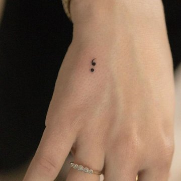 Kleines Semikolon Tattoo auf dem Finger