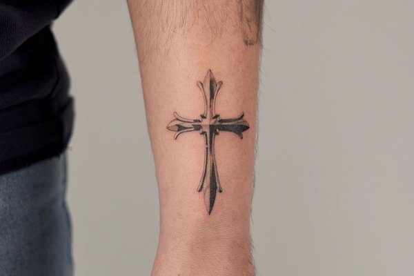 Schwarzes Kreuz Tattoo am Handrücken mit klaren Linien