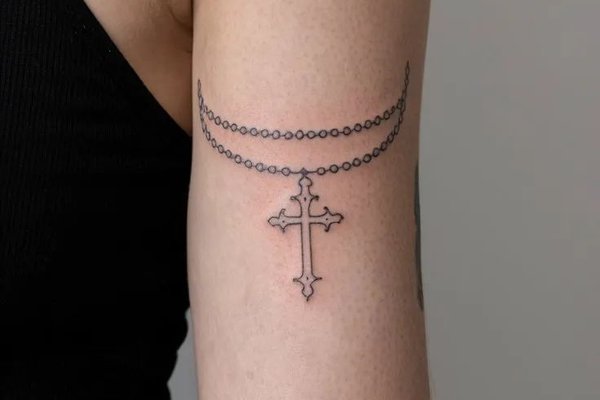 Symbolisches Kreuz Tattoo auf der linken Hand
